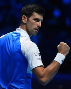 a man holding a tennis racquet in his right hand and fist raised up