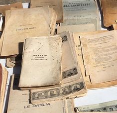 many old books are stacked on top of each other