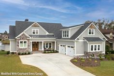 a large gray house with two garages on the front and one story above it