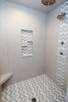 a bathroom with a shower, toilet and sink in it's corner area that has white tile on the walls