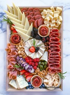 an assortment of meats and cheeses on a tray