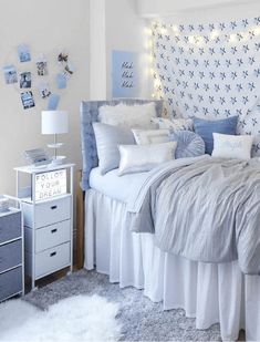 a bed with white sheets and pillows in a room that has lights on the headboard