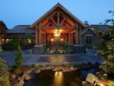 a large house with a pond in front of it and lights hanging from the roof