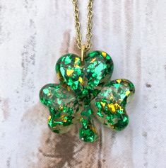 "Show your green for St. Patrick's Day! These shiny shamrocks will catch everyone's eye! Matching earrings are available as well. Choose green and gold in Foil or Glitter. Long necklace, 26\" 18K gold-plated chain." Green Necklaces For Valentine's Day Party, Cadmium-free Green Jewelry For Gifts, St Patricks Day Accessories Women, St Patricks Day Jewelry, Gold Jewelry For St. Patrick's Day Gift, 4 Leaf Clover Resin, Jewellery Resin, St Patrick’s Earrings, Shamrock Necklace