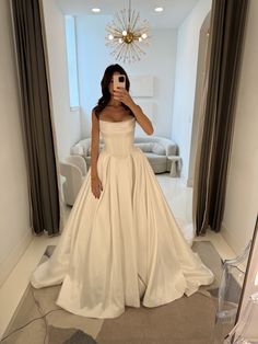 a woman taking a selfie in a wedding dress while standing in front of a mirror