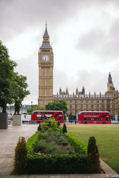 the big ben clock tower towering over the city of london, england with double decker buses in the foreground