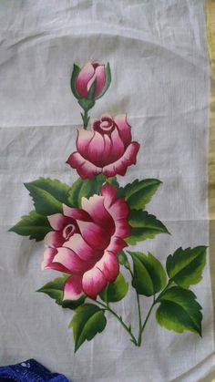 two pink flowers on a white cloth with green leaves