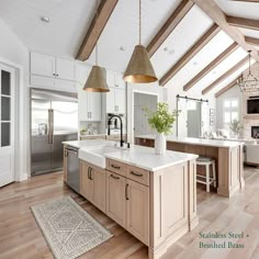 a large kitchen with an island and two pendant lights hanging from the ceiling above it