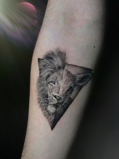 a lion tattoo on the arm with a triangle in it's head and eyes