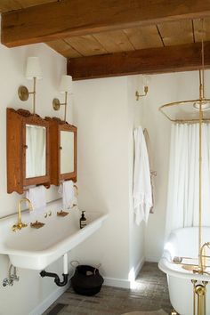 a bath room with a tub a sink and a mirror on the wall in it