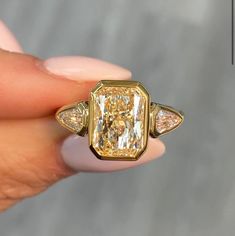 a fancy yellow diamond ring with three pear shaped diamonds on the sides and an old - fashioned band