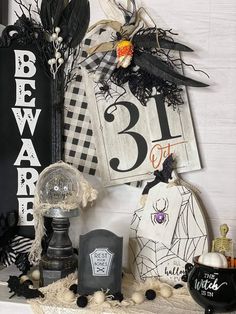 halloween decorations are displayed on the mantle in front of a house number sign and other items