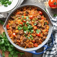 a large pot filled with meat and rice next to some tomatoes, parsley on the side