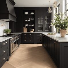 a large kitchen with black cabinets and white counter tops, an island in the middle