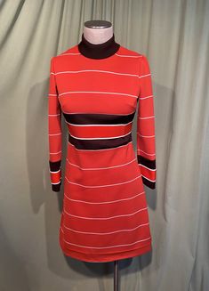 "This is a cute vintage dress from the 70s. Label reads, Verona Knits. No size tags. The bust measures 32\", waist 30\", see measurements below. Made of a rust orange, brown & white horizontal stripe polyester knit. It has long sleeves & a mock turtle neck. The rust orange stripes inside the dark brown stripes at the waist on the sleeves & a slightly thicker knit. The dress is skims the body & it is not lined. The sleeves are wrist length. The neckline is fold over mock turtleneck. Zips in the b Retro A-line Vintage Dress For Fall, Retro Fitted A-line Vintage Dress, Fitted Retro Vintage Dress For Fall, Fitted Retro A-line Vintage Dress, Fitted A-line Retro Vintage Dress, Retro Vintage Dress For Fall, Retro Fitted Knee-length Vintage Dress, Fitted Retro Vintage Dress Knee-length, Fitted Retro Knee-length Vintage Dress