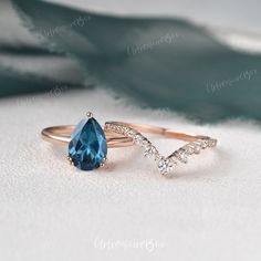 two rings with blue topaz and white diamonds are on the table next to each other