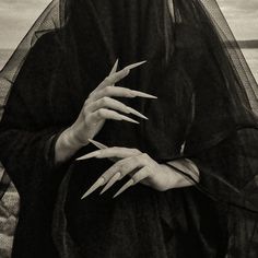 a woman with white nails and black veil