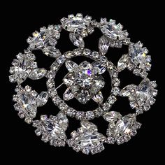 This large round pin is a fine example of the vintage large rhinestone pins with these amazing designs and brilliant that are hard to find. The pin is a three dimensional design with at center large chaton rhinestones domed flower  the shape of flower is surrounded by many medium Marquise rhinestone accentuated by smaller round chaton rhinestones.   the outer row is made up of more large Marquise faceted shaped clear rhinestones surrounded by  medium round rhinestones all in a silvertone setting 50s Vintage, Rhinestone Brooches, Clear Rhinestones, Three Dimensional, Original Design, Brooch Pin, Original Designs, Vintage Jewelry, Silver Tone