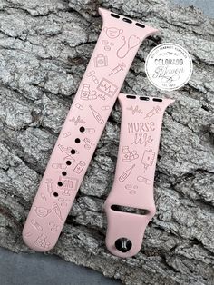 the pink watch band has drawings on it and is next to an apple watch strap