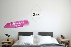 there is a bed with two pillows on it and a sign above the headboard