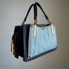 Coach Dreamer 21 Denim Mini Satchel/Crossbody Purse B2547 Mini Sized Bag; 7-3/4"W X 5-1/2"H X 4"D 4"L Handles; 22"L Detachable Strap Drop Zipper Closure Gold-Tone Exterior Hardware 1 Interior Zip Pocket & 2 Slip Pockets Cotton; Trim: Leather : Modern : Great Used Condition - Like New, All Stitching Intact, One Tiny Stain On Exterior, Some Light Staining On Interior, Missing Coach Keychain/Tag. : Modern Sizing Is Justified By Measurements In Inches - Please Check All Detailed Measurements Above F Coach Dreamer Bag, Coach Denim, Coach Keychain, Denim Mini, Crossbody Purse, Blue Gold, Purses Crossbody, The Dreamers, Bags Handbags