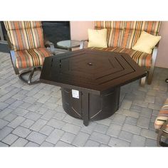 a table and chairs sitting on top of a brick floor next to two couches