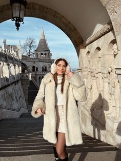 a woman in a white coat and black boots