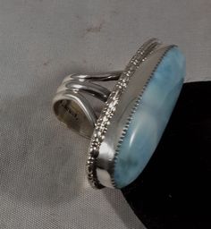 This Natural Larimar Stone is set in Sterling Silver with Silver Egg Shape Wire Around the Larimar Setting. This is a large Larimar Stone which weight 46 Carets. Larimar is Found in the Dominican Republic. This Ring is a Size 7 3/4. The Handmade Ring Shank is 8.5mm wide. This Natural Larimar Stone Measures 42mm by 16mm. Total weight of This Handmade Ring is 23.1 Grams. I Stamped the inside of the Ring Shank with Sterling and PT for Authentication. Horse Ring, Larimar Ring, Larimar Rings, Ring Shank, Larimar Stone, Royston Turquoise, The Dominican Republic, Egg Shape, Blue Band