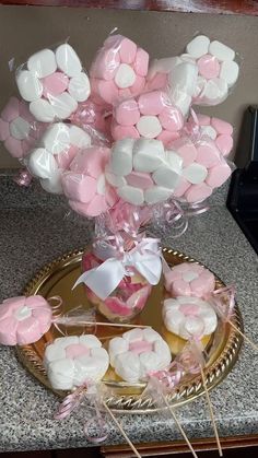 pink and white marshmallows in a basket with lollipops on sticks