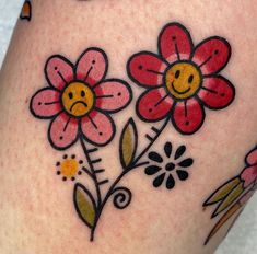 a woman's thigh with flowers and smiley face drawn on the bottom part of her leg