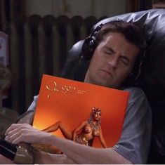 a man laying in a chair holding an orange book with the title queen of pop written on it