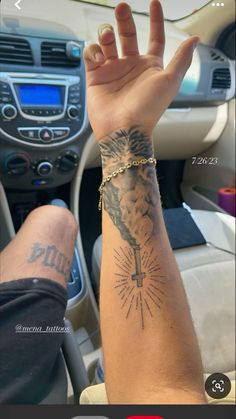 a person holding their hand up in the air with tattoos on his arm and wrist