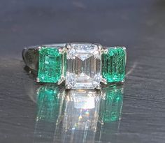 "Emeralds were examined and tested by a professional gemologist.  Comes with an apprisal letter. Choose from sterling silver or 14k gold options.  You will love this beautiful classic emerald/moissanite ring. You will get a lot of complaints about it and your girlfriends will be envious.  Deep Rich glowing emerald ring with a bright firing moissanite center stone. Set in friction 4 prong setting to allow light behind the gem for amazing sparkle and light reflection.  You will love this ring it's Multi-stone Emerald Cut Emerald Ring For May Birthstone, Gia Certified White Baguette Cut Emerald Ring, Emerald-cut Multi-stone Diamond Emerald Ring, Luxury Multi-stone Emerald Cut Emerald Ring, Elegant Multi-stone Emerald Ring In Platinum, Sterling Silver Multi-stone Green Emerald Ring, 35th Wedding Anniversary, Engagement Ring Moissanite, Natural Emerald Rings