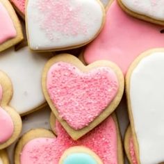 heart shaped cookies with pink, blue and white frosting on top are arranged in the shape of hearts