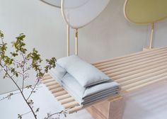 three round mirrors hang on the wall behind a bench with folded linens in front of it