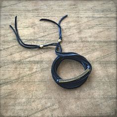 a black leather cord with two metal clasps on top of it, sitting on a table