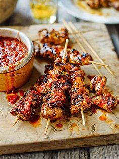 chicken skewers with marinara sauce on a cutting board