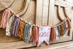 a banner with tassels hanging from it's sides on a wooden door