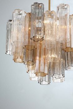 a large chandelier made out of glass tubes hanging from a ceiling fixture in a room