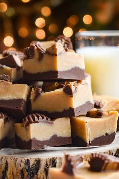 a pile of chocolate fudges next to a glass of milk