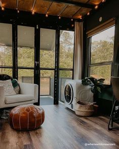 a living room filled with furniture and windows next to a wooden floor covered in lights