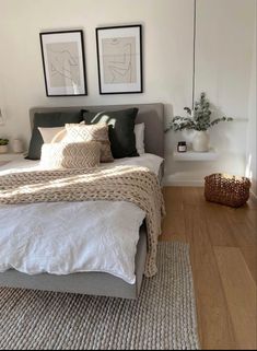 a bed sitting in a bedroom next to two framed pictures on the wall above it