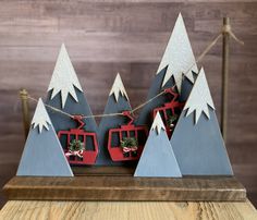 a wooden table topped with christmas trees and ski lift decorations on top of each other