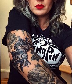 a woman with grey hair and tattoos on her arm