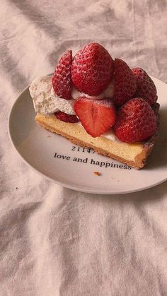 a piece of cake with strawberries on top sits on a plate that says,