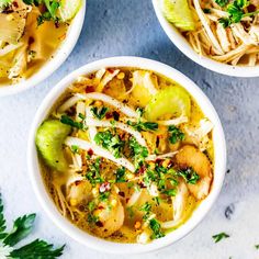 three white bowls filled with food on top of a table