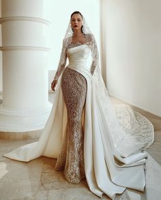 a woman in a wedding dress standing next to a large white pillar with her hands on her hips