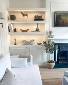 a living room filled with furniture and a fire place next to a wall mounted book shelf