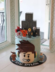 a lego themed birthday cake is displayed in front of a window