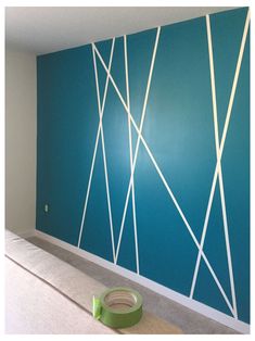 an empty room with blue walls and white lines painted on the wall, along with a green tape